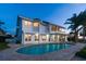 Backyard with a refreshing pool, patio, and lush landscaping, enhanced by large windows at 119 Carlyle Cir, Palm Harbor, FL 34683