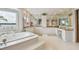 Large bathroom featuring a jacuzzi tub, double sinks, and marble countertops at 119 Carlyle Cir, Palm Harbor, FL 34683