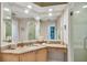 Bathroom with granite counters, wood cabinets, and large mirror at 119 Carlyle Cir, Palm Harbor, FL 34683