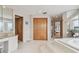 Bathroom featuring access to bedroom, a bay window with waterfront views, and a jacuzzi tub at 119 Carlyle Cir, Palm Harbor, FL 34683