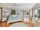 Bedroom with hardwood floors, queen bed, and access to the sunroom and water views at 119 Carlyle Cir, Palm Harbor, FL 34683