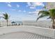Waterfront deck with palm trees and dock and boat lift in view on a beautiful sunny day at 119 Carlyle Cir, Palm Harbor, FL 34683