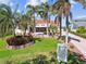 Manicured front lawn and tropical landscaping leading to a grand home, creating a welcoming curb appeal at 119 Carlyle Cir, Palm Harbor, FL 34683