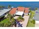 Beautiful waterfront home featuring a circular driveway, lush tropical landscaping, and a covered portico entrance at 119 Carlyle Cir, Palm Harbor, FL 34683