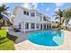 Stunning waterfront home with a refreshing pool, lush lawn, and private boat dock on a sunny day at 119 Carlyle Cir, Palm Harbor, FL 34683