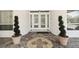 Elegant double front doors framed by decorative plants and windows, creating a welcoming entry at 119 Carlyle Cir, Palm Harbor, FL 34683