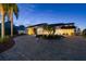 This home boasts a circular driveway, lush landscaping, and mature palms at 119 Carlyle Cir, Palm Harbor, FL 34683
