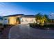 Charming front exterior of home featuring a circular driveway, lush landscaping, and mature palms at 119 Carlyle Cir, Palm Harbor, FL 34683