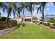 Expansive front lawn showcasing tropical landscaping and a stately home, perfect for outdoor enjoyment at 119 Carlyle Cir, Palm Harbor, FL 34683