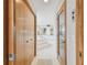 Hallway leading to bathroom with wood doors and trim, and white tile floors at 119 Carlyle Cir, Palm Harbor, FL 34683