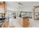 Bright kitchen featuring wood cabinets, granite counters, island, and adjacent dining area overlooking waterfront view at 119 Carlyle Cir, Palm Harbor, FL 34683