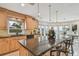 Bright kitchen featuring wood cabinets, granite counters, island with eat-in breakfast bar, and waterfront view at 119 Carlyle Cir, Palm Harbor, FL 34683