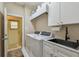 Bright laundry room with a sink, marble countertops, ample storage space, and a washer and dryer at 119 Carlyle Cir, Palm Harbor, FL 34683