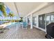 Covered patio area with outdoor dining set overlooking the swimming pool and waterfront at 119 Carlyle Cir, Palm Harbor, FL 34683