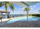 Inviting backyard pool overlooking the bay, complete with brick paver patio and covered lounge area at 119 Carlyle Cir, Palm Harbor, FL 34683