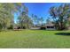 Spacious backyard with lush green grass and mature trees, offering plenty of room for outdoor activities at 12102 Hazen Ave, Thonotosassa, FL 33592