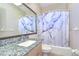 Full bathroom features a large mirror, granite counter, and tub with blue marble curtain at 12102 Hazen Ave, Thonotosassa, FL 33592