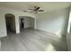 Open-concept living room with grey wood-look floors and stylish archways to other rooms at 1218 Halapa Way, Trinity, FL 34655