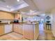 Charming kitchen with an open layout featuring granite countertops, a breakfast bar, and travertine flooring at 19029 Us Highway 19 N # 29E, Clearwater, FL 33764
