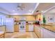 Well-lit kitchen featuring wooden cabinets, travertine floors, granite countertops, and modern appliances at 19029 Us Highway 19 N # 29E, Clearwater, FL 33764