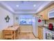 Modern kitchen with granite countertop, stainless steel sink, breakfast bar, and travertine tile flooring at 19029 Us Highway 19 N # 29E, Clearwater, FL 33764
