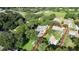 Aerial view showcases a beautiful blue home on a sprawling, tree-filled lot with a pool at 1975 Levine Ln, Clearwater, FL 33760