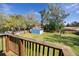 Backyard view from deck showcasing a lush lawn, mature trees, and a charming shed at 1975 Levine Ln, Clearwater, FL 33760