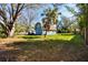 Backyard features include a barn style building with a balcony, large trees, and green grass at 1975 Levine Ln, Clearwater, FL 33760