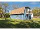 The property features a blue barn-style building with a balcony overlooking the backyard at 1975 Levine Ln, Clearwater, FL 33760