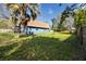 Well-maintained backyard featuring a lush green lawn, a detached garage, and mature trees at 1975 Levine Ln, Clearwater, FL 33760