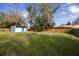 Spacious backyard with lush green grass, a storage shed and wooden privacy fence at 1975 Levine Ln, Clearwater, FL 33760