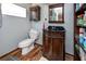 Cozy bathroom with dark vanity, tiled floors, and storage shelves at 1975 Levine Ln, Clearwater, FL 33760