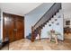 Inviting foyer showcases tile floors, a staircase with wood railing, and closet for storage creating a warm entrance at 1975 Levine Ln, Clearwater, FL 33760