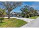 Charming blue two-story home with lush landscaping and mature trees on a well-manicured lawn at 1975 Levine Ln, Clearwater, FL 33760