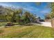 Beautiful front yard with lush landscaping and a long driveway leading to a garage at 1975 Levine Ln, Clearwater, FL 33760