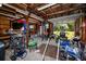 View of a cluttered garage with tools and equipment, featuring a high ceiling and natural light at 1975 Levine Ln, Clearwater, FL 33760