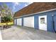 Exterior garage showing a double door and single door with adjacent rocking chairs at 1975 Levine Ln, Clearwater, FL 33760