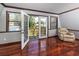 Bright living area with hardwood floors, a cozy armchair, and French doors opening to the outside deck at 1975 Levine Ln, Clearwater, FL 33760