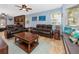 Spacious living room featuring leather seating, a brick fireplace, and a cozy window seat at 1975 Levine Ln, Clearwater, FL 33760