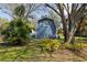 Unique outbuilding with charming details, surrounded by mature trees, and lush landscaping at 1975 Levine Ln, Clearwater, FL 33760