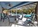 Screened patio with ceiling fans, a seating area and lounge chairs overlooks the outdoor pool at 1975 Levine Ln, Clearwater, FL 33760