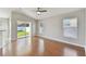 Bright living room with wood flooring, a ceiling fan, and sliding glass doors leading to the backyard at 20426 Autumn Fern Ave, Tampa, FL 33647