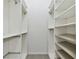 Spacious walk-in closet featuring white shelving units and ample storage space for organized living at 20426 Autumn Fern Ave, Tampa, FL 33647