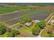 Aerial view showcasing the property, including the home, lush fields, and additional outbuildings at 2102 W Knights Griffin Rd, Plant City, FL 33565