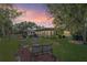 Outdoor living space featuring a patio, gazebo, enclosed porch, and lush lawn at twilight at 2102 W Knights Griffin Rd, Plant City, FL 33565