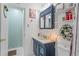 Stylish bathroom features a vanity with blue cabinets, white countertop, and decorative wreath and shelf at 2102 W Knights Griffin Rd, Plant City, FL 33565