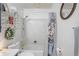 Bathroom with a tub shower, white tile walls, and decorative accents, including a cotton-themed shower curtain at 2102 W Knights Griffin Rd, Plant City, FL 33565