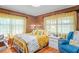 Bedroom featuring hardwood floors, paneled walls, yellow accents, and natural light from the curtained windows at 2102 W Knights Griffin Rd, Plant City, FL 33565