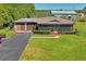 Aerial view of a home featuring a screened porch, two-car garage, and a neatly paved driveway at 2102 W Knights Griffin Rd, Plant City, FL 33565