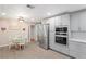 Open-concept kitchen boasts stainless steel appliances, light gray cabinets, and a dining area with a round table at 2102 W Knights Griffin Rd, Plant City, FL 33565